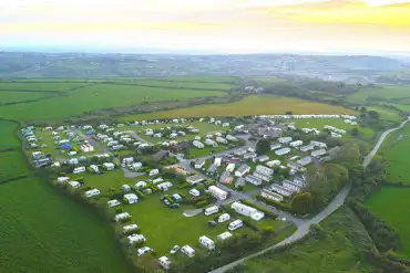 Aerial shot of Lanyon Holiday Park at sunset, surrounded by fields