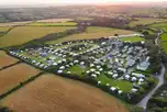 Aerial shot of Lanyon Holiday Park at sunset, surrounded by fields