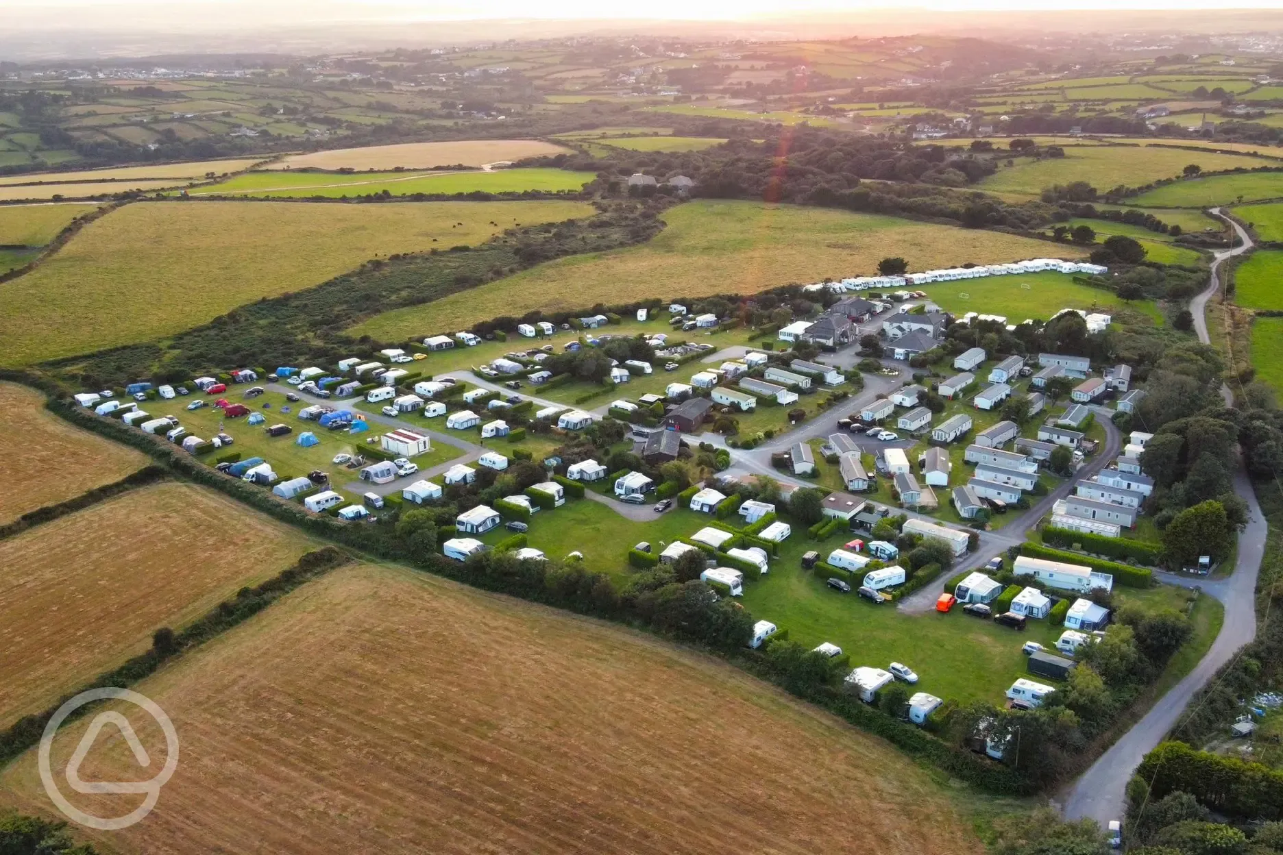 Aerial shot of Lanyon Holiday Park at sunset, surrounded by fields