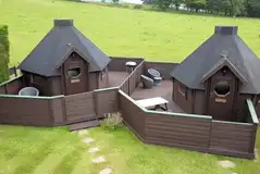 Double camping pods with enclosed decking areas and seating