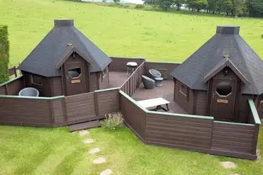 Double camping pods with enclosed decking areas and seating