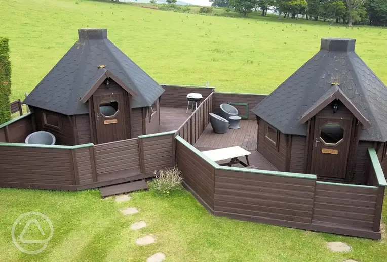Double camping pods with enclosed decking areas and seating