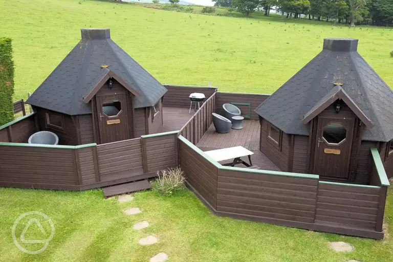 Double camping pods with enclosed decking areas and seating