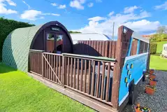 Twin camping pod with a gated decking area and outdoor seating