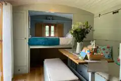 Shepherd's hut interior with a double bed and seating area