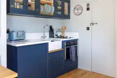 Shepherd's hut kitchen with a sink, hob, fridge, freezer and dishwasher