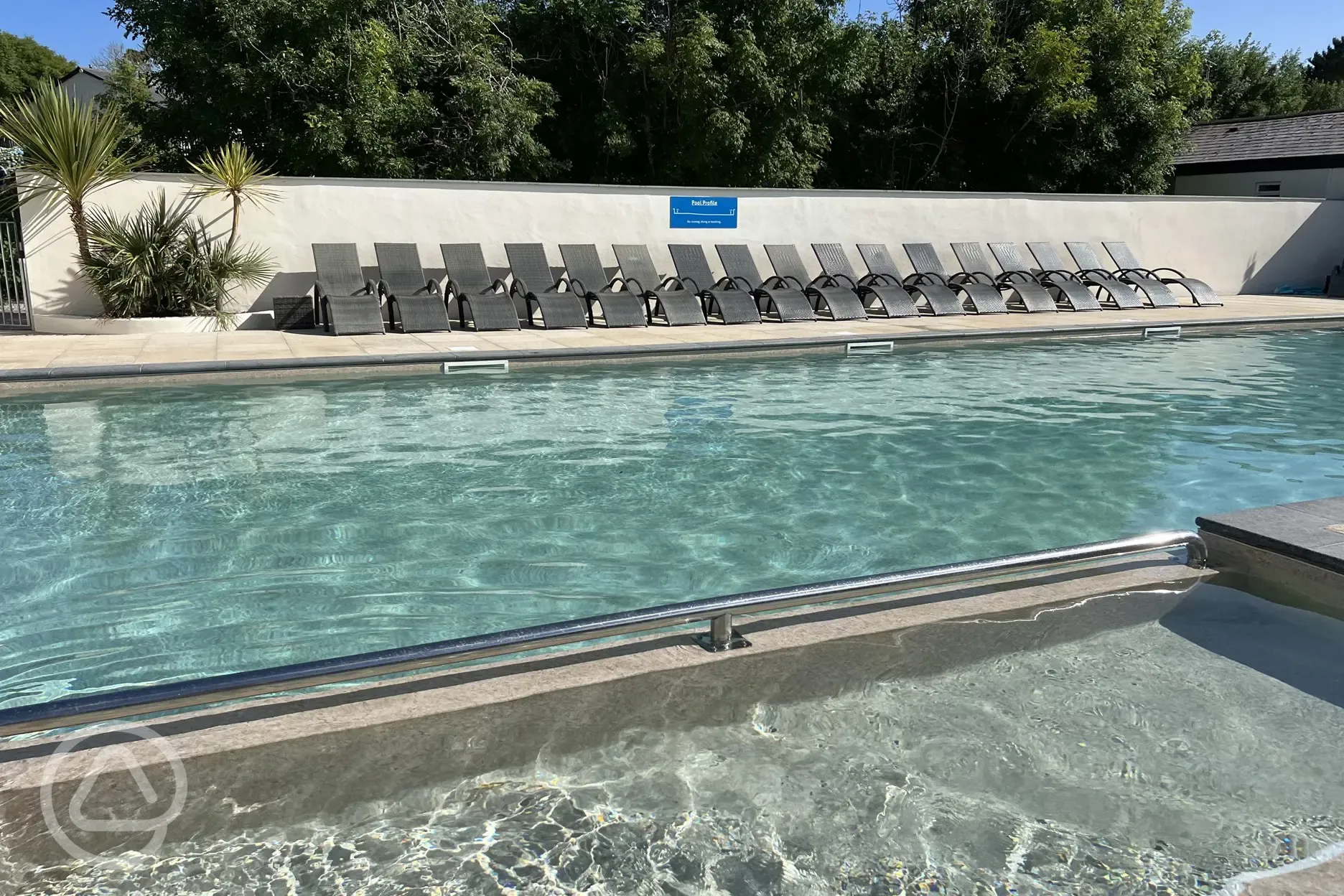 Outside heated swimming pool with sun loungers