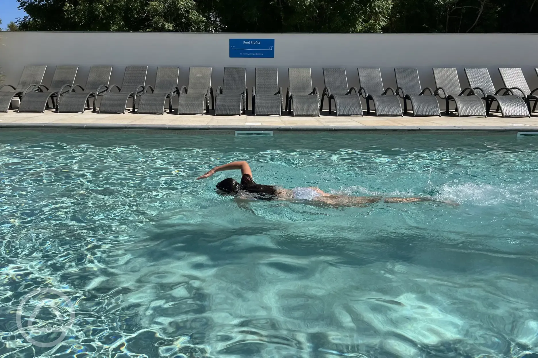 Outside heated swimming pool with sun loungers