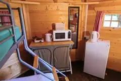 Camping cabin kitchen with fridge, kettle, microwave and coffee table Camping cabin kitchen with fridge, kettle, microwave and coffee table