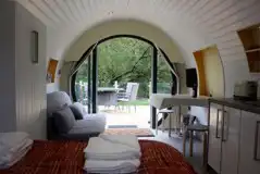 Ensuite glamping pod double sofa bed, dining area and TV