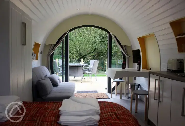 Ensuite glamping pod double sofa bed, dining area and TV