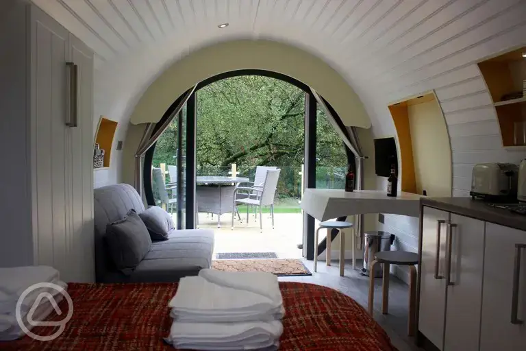 Ensuite glamping pod double sofa bed, dining area and TV