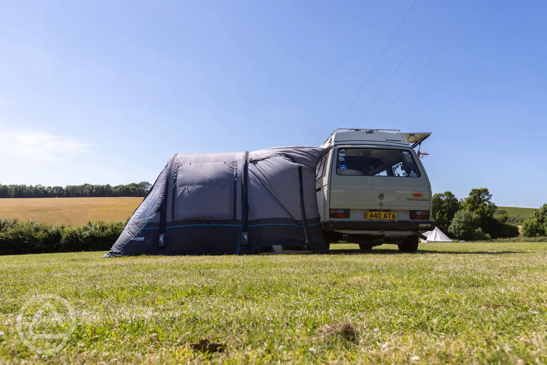 Campervan with an awning on an electric grass pitch
