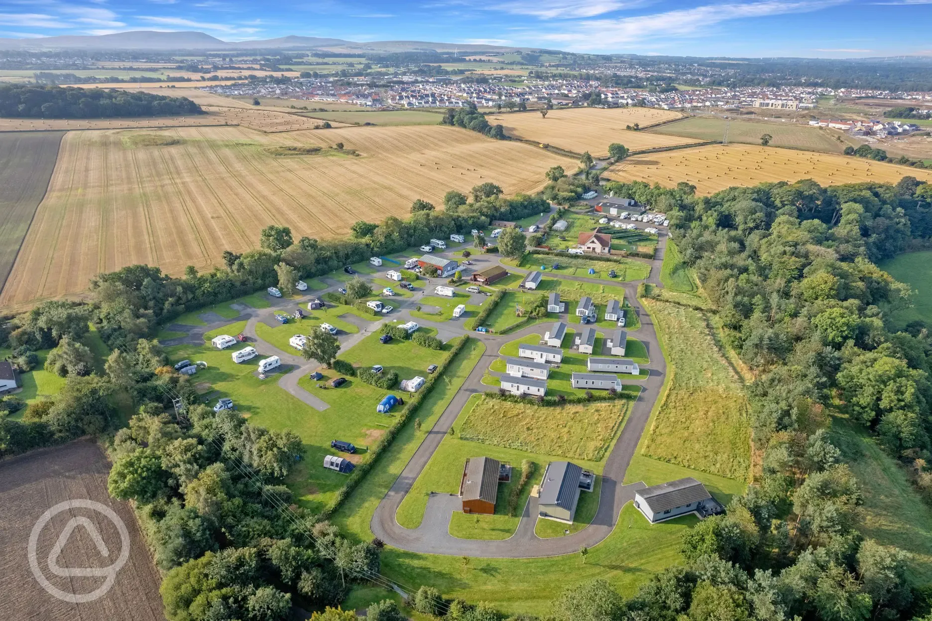 Aerial view of Linwater Caravan Park with woodland and fields beyond