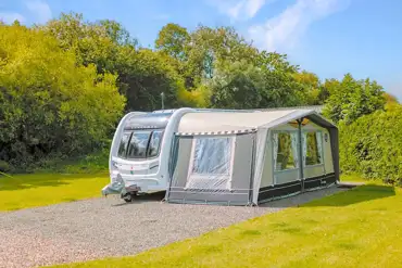 Fully serviced hardstanding pitches with a caravan with awning