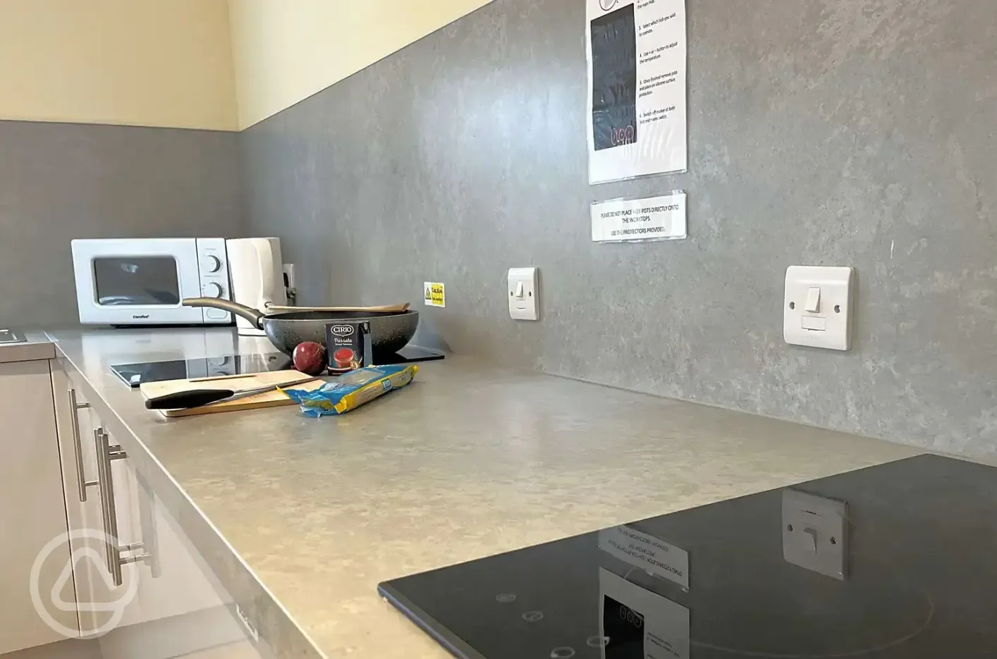 Communal kitchen with seating, kettle, microwave, sinks and some essential items