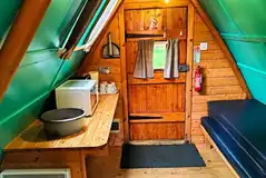 Camping pod interior with four sleeping platforms and a mini kitchen area Camping pod interior with four sleeping platforms and a mini kitchen area