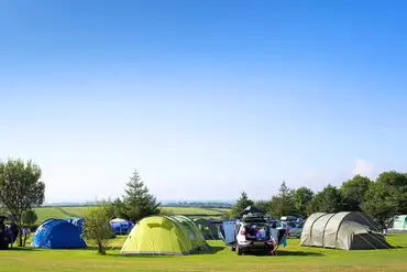 Grass pitches at Little Kings Holiday Park with countryside and sea views