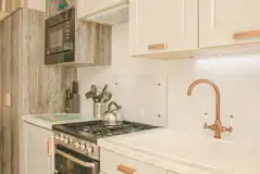 Jurassic Escape Pod kitchen with a gas hob, microwave, kettle, and sink