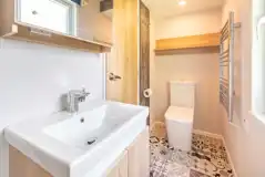 Jurassic Escape Pod ensuite with a shower, toilet, and handwashing sinks