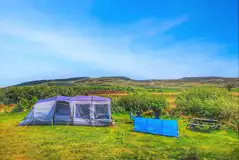 Large tent on a non electric grass pitch with distant mountain views