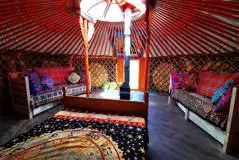 Yurt interior with a double bed, and a small fold-out mattress