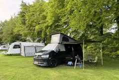 Grass 11m x 7m touring pitches with optional 16 amp hook ups in the main field