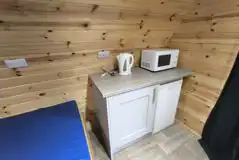 Ensuite pod kitchen area with a mini fridge, microwave and kettle