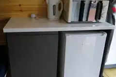 Ensuite pod kitchen area with a mini fridge, microwave and kettle
