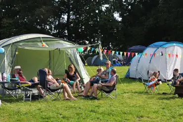 Family sitting outside their tents having fun