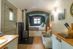 Bertie's Retreat interior with a double bed, kitchenette, and wood burning stove