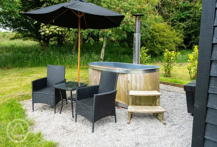 Robin's Nest glamping cabin bed outdoor seating area and hot tub