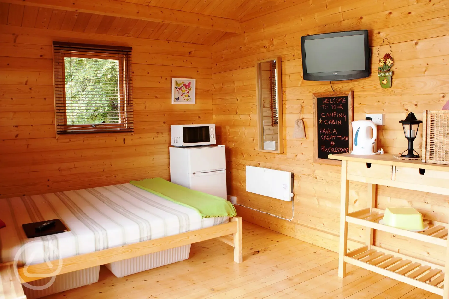 Camping cabin with a king size bed, TV, fridge, kettle and microwave