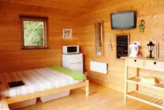 Camping cabin with a king size bed, TV, fridge, kettle and microwave