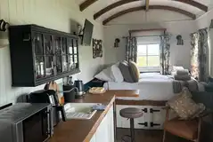 Shepherd's Rest interior with a double bed, bedding, towels, and kitchenette