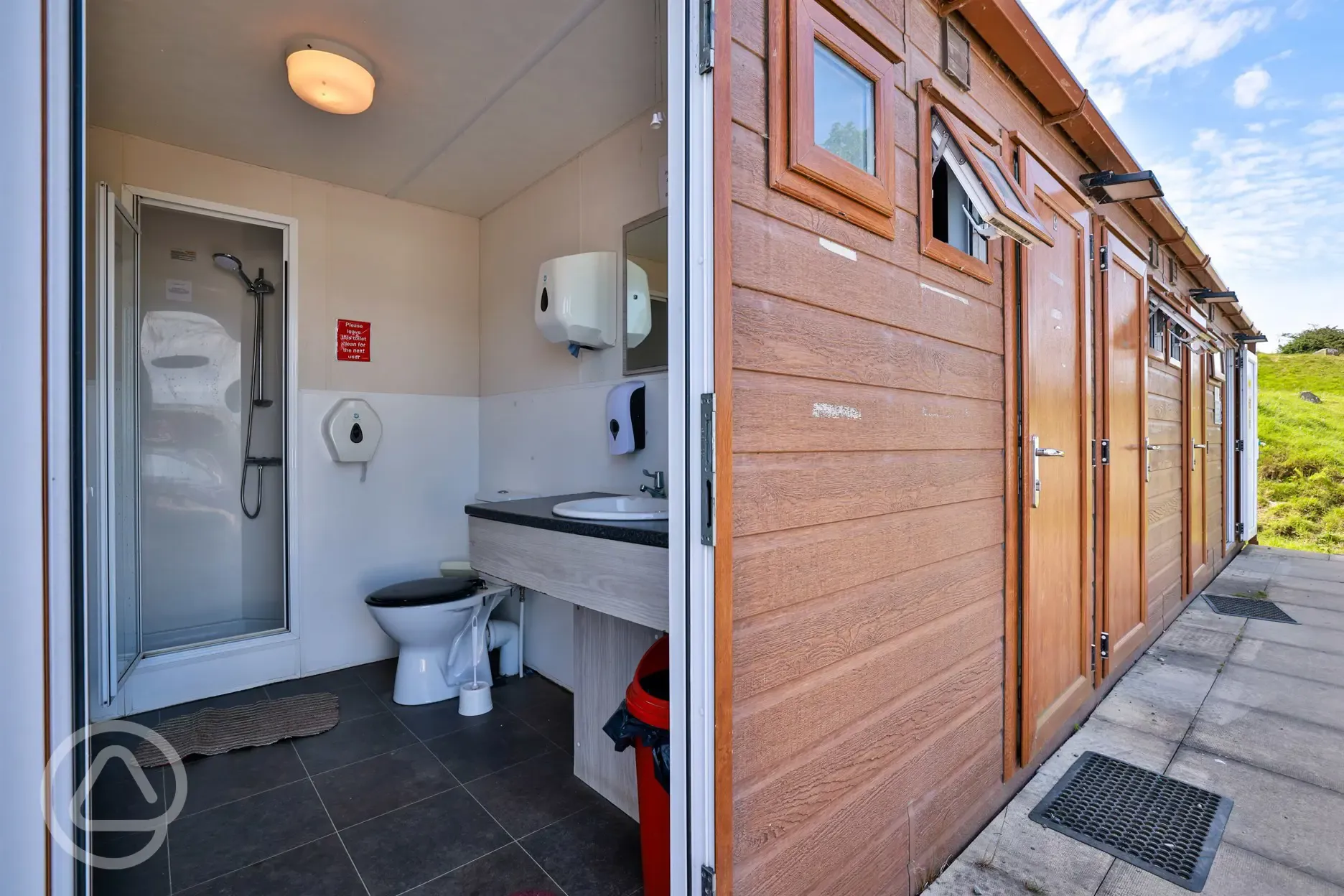 Individual bathrooms at Bwlchgwyn Farm with showers, toilets, and sink Individual bathrooms at Bwlchgwyn Farm with showers, toilets, and sink