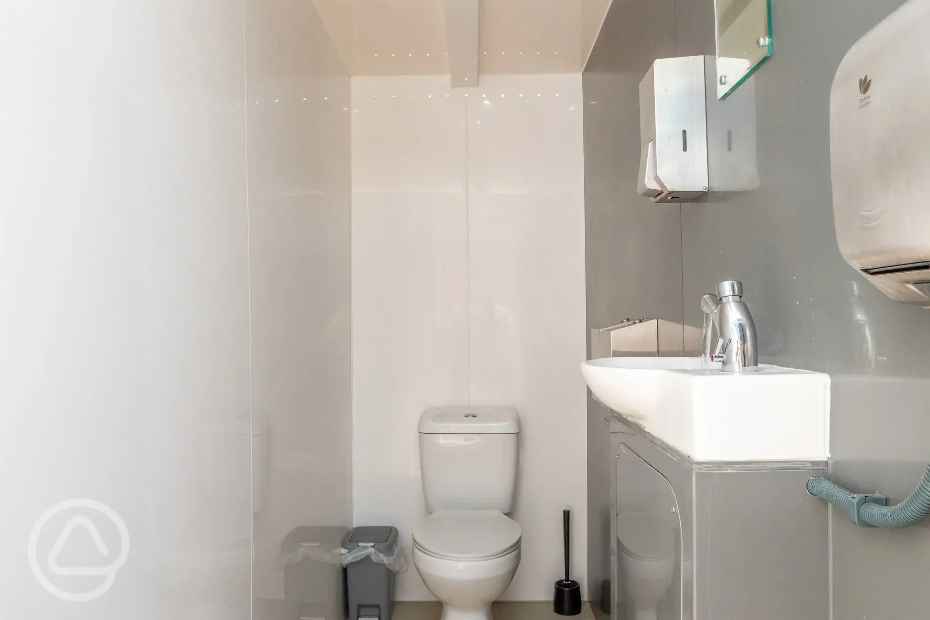 Private toilets with a sink, mirror, and tap