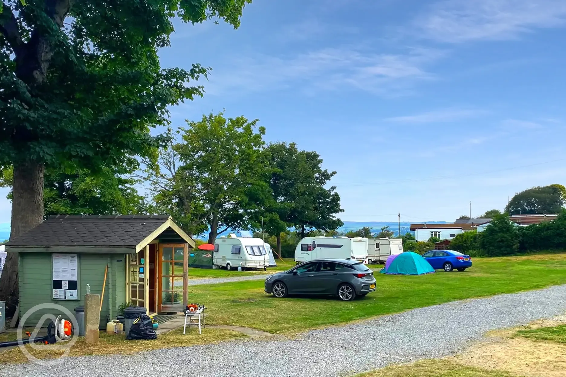 Grass pitches with the washing up area and tourism hut