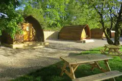 Camping pods with surrounding trees and picnic benches
