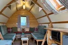Camping pod interior with sofas and a small kitchenette