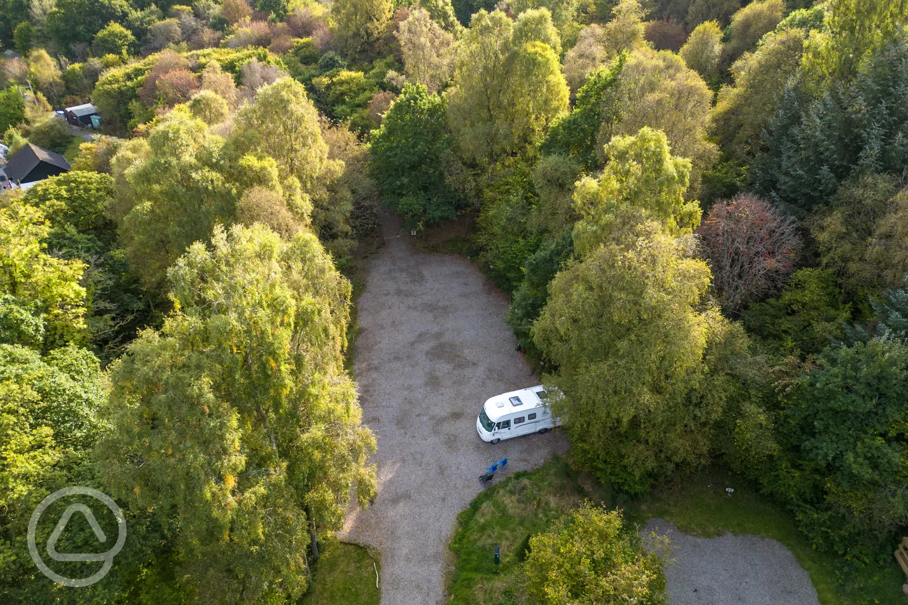 Aerial of gravel pitches at Cobleland Campsite surrounded by trees