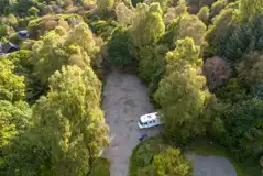 Aerial of gravel pitches at Cobleland Campsite surrounded by trees