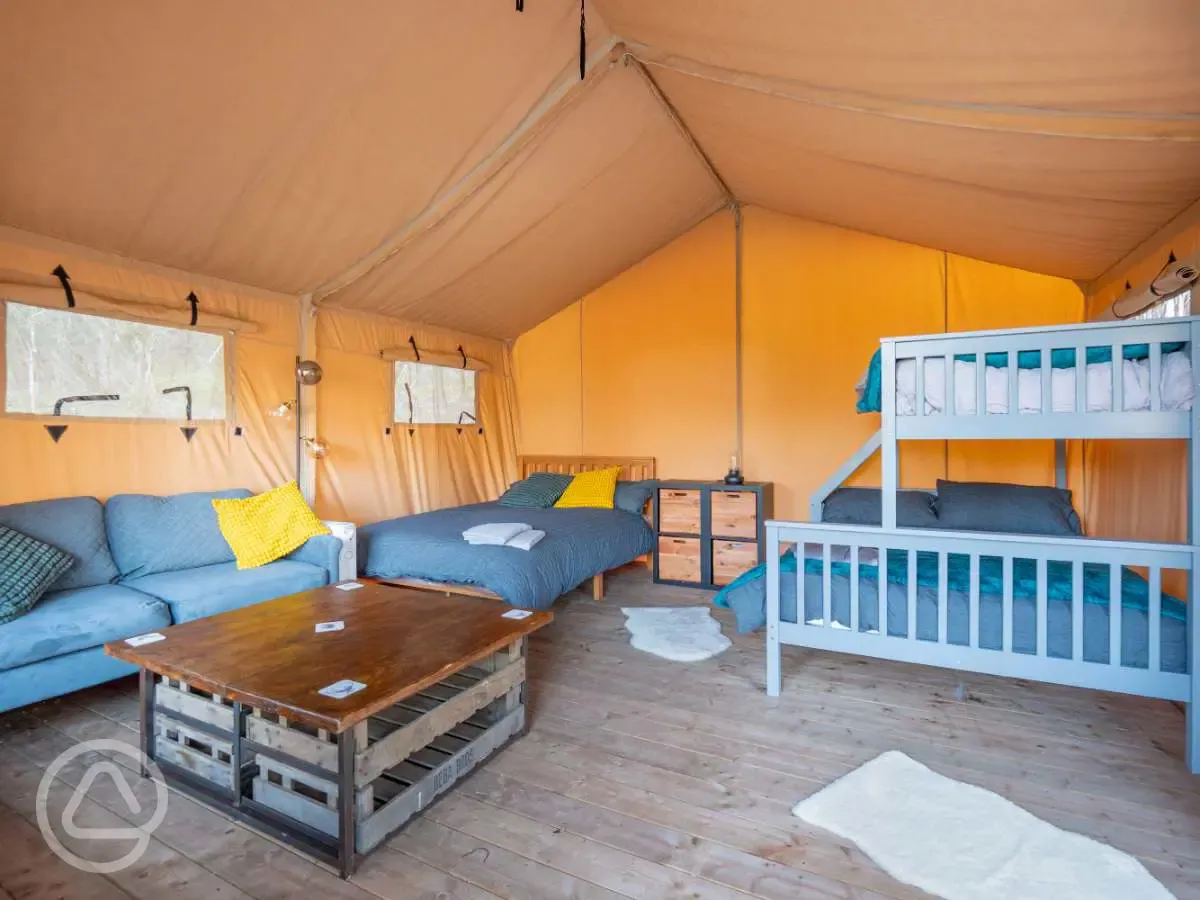Safari tent interior with double bed and triple bunk bed