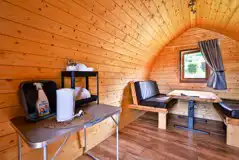 Log pod interior with chairs that convert to a double bed Log pod interior with chairs that convert to a double bed