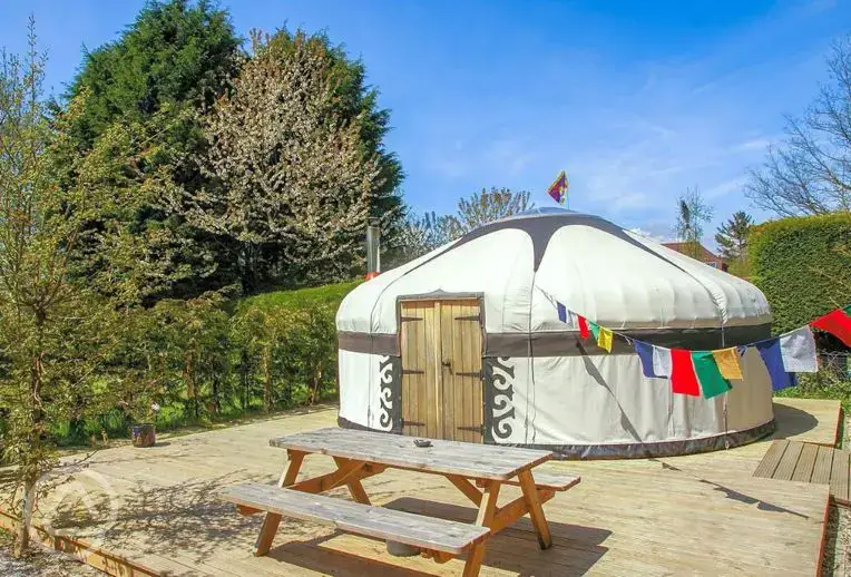 Yurt on a decking area with a picnic bench