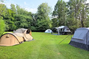 Camping field enclosed by hedges and trees