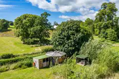 Aerial of a wooden cabin with a sheltered kitchen and hot tub