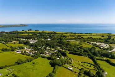 Aerial view of East Crinnis Holiday Park, towards the coast and Carlyon Bay