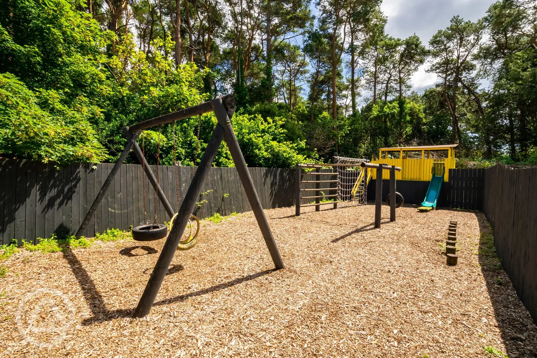 Play area with a climbing frame, slide and swing