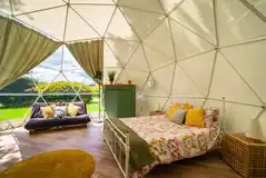Geodome interior with a king size bed, sofa bed and large windows